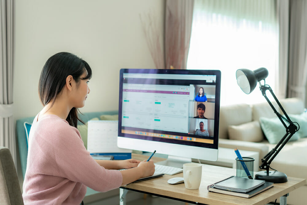 Woman sitting at her desk on a video meeting with three other people